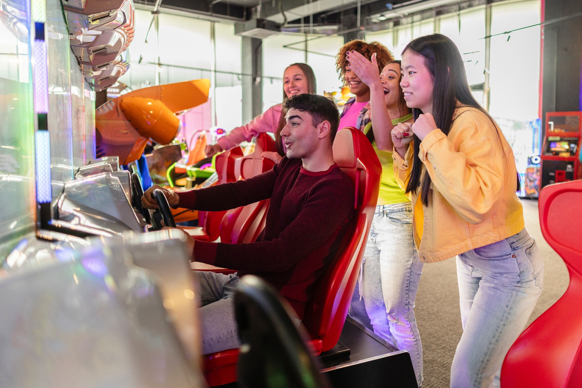 Friends Cheering While Playing Arcade Racing Game